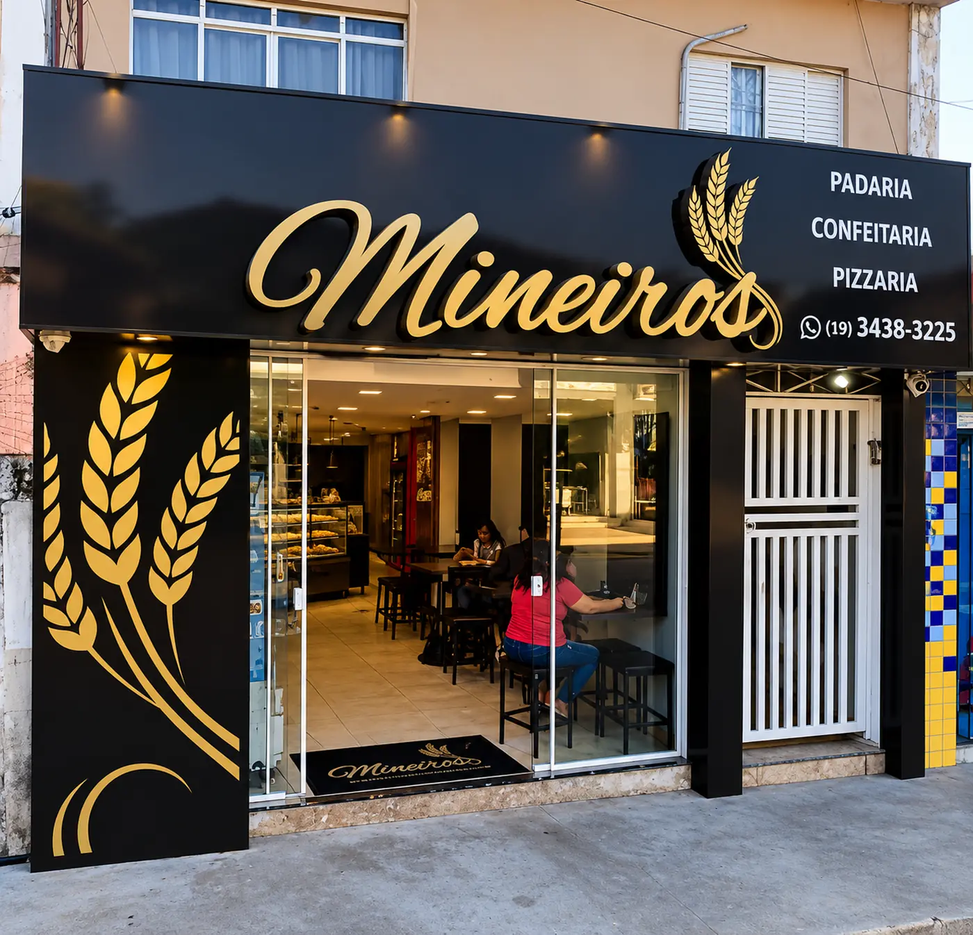 Fachada preta e dourada da padaria Mineiros